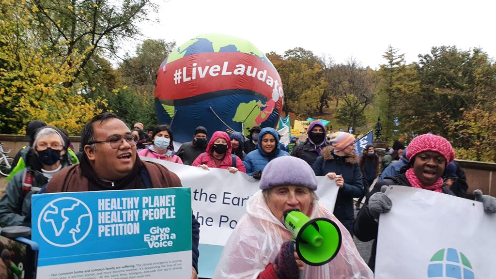 Isabella Harding (with megaphone) leads the Laudato Si’ Movement group during Saturday’s march for climate justice in Glasgow.